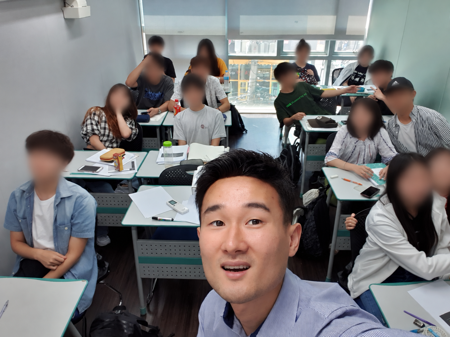 Eric and his students in a Seoul classroom, July 2019; student faces and identifying details are blurred